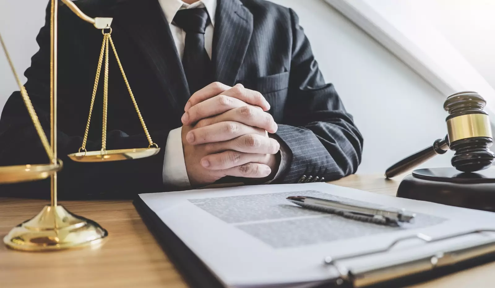 Lawyer sitting on the table with pen, paper and gavel